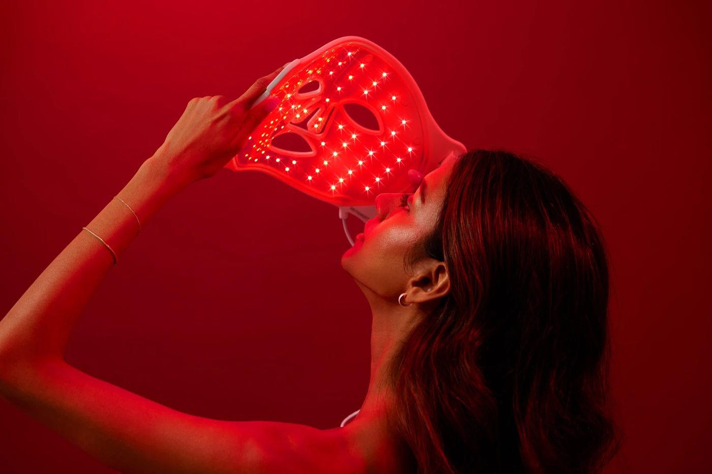 Omnilux LED-Lichttherapiemaske vor rotem Hintergrund