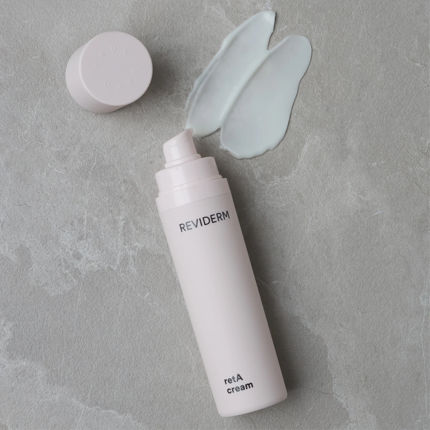 REVIDERM retA cream mit Cremetextur auf kühlem grauem Stein